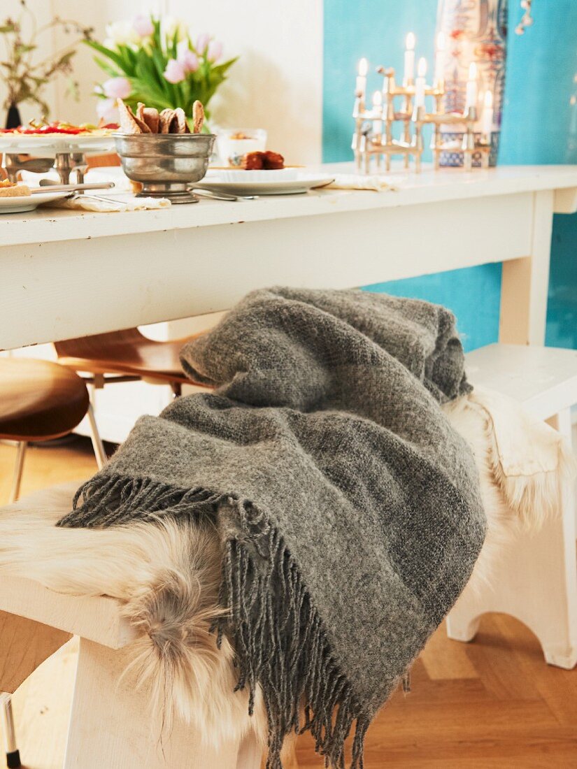 Fringed blanket on wooden bench