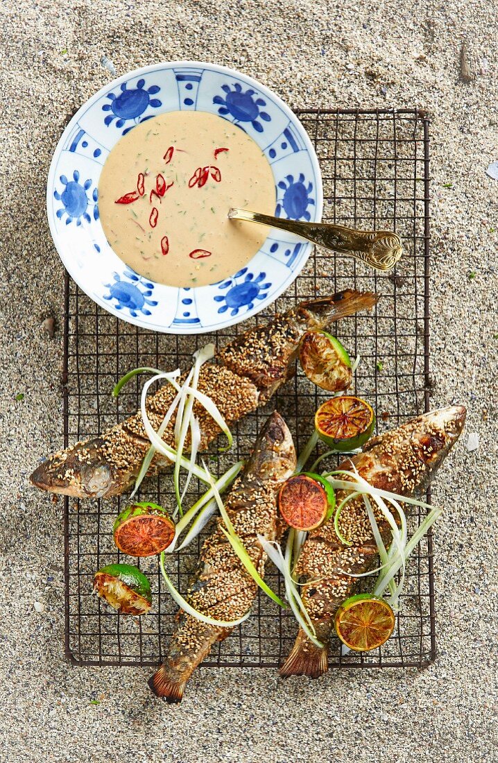 Grilled grey mullet with a sesame seed coating served with peanut sauce