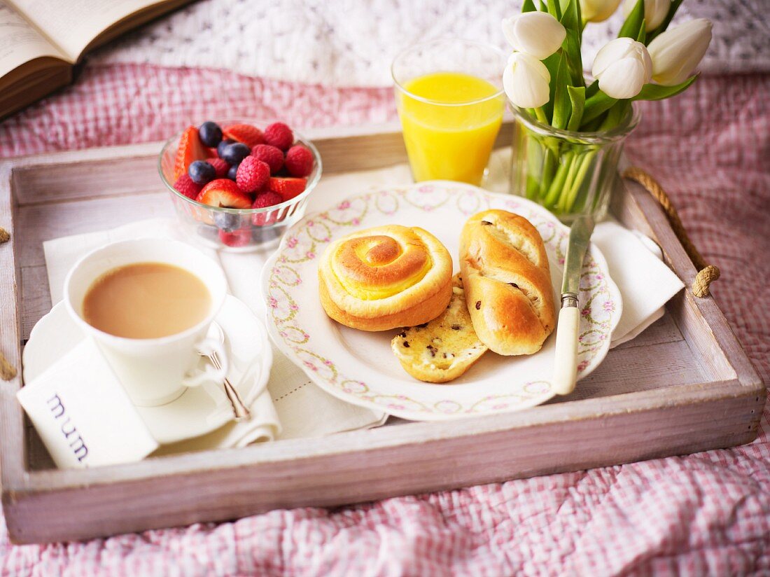 A breakfast tray with white tulips