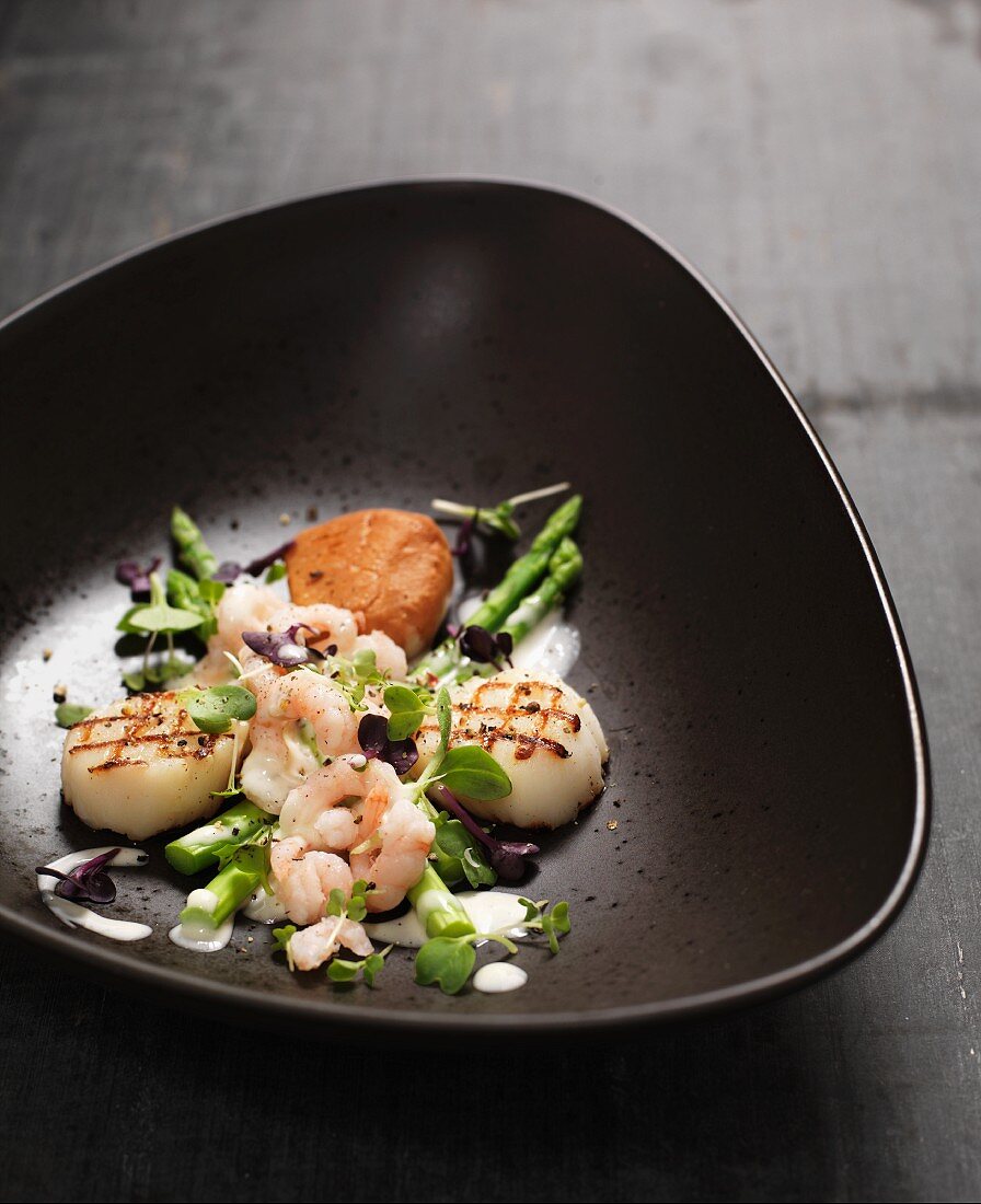Cod with asparagus, scallops and prawns