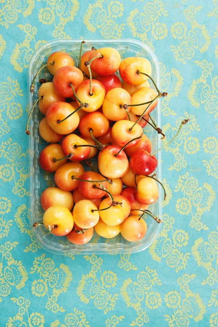A punnet of yellow cherries seen from above