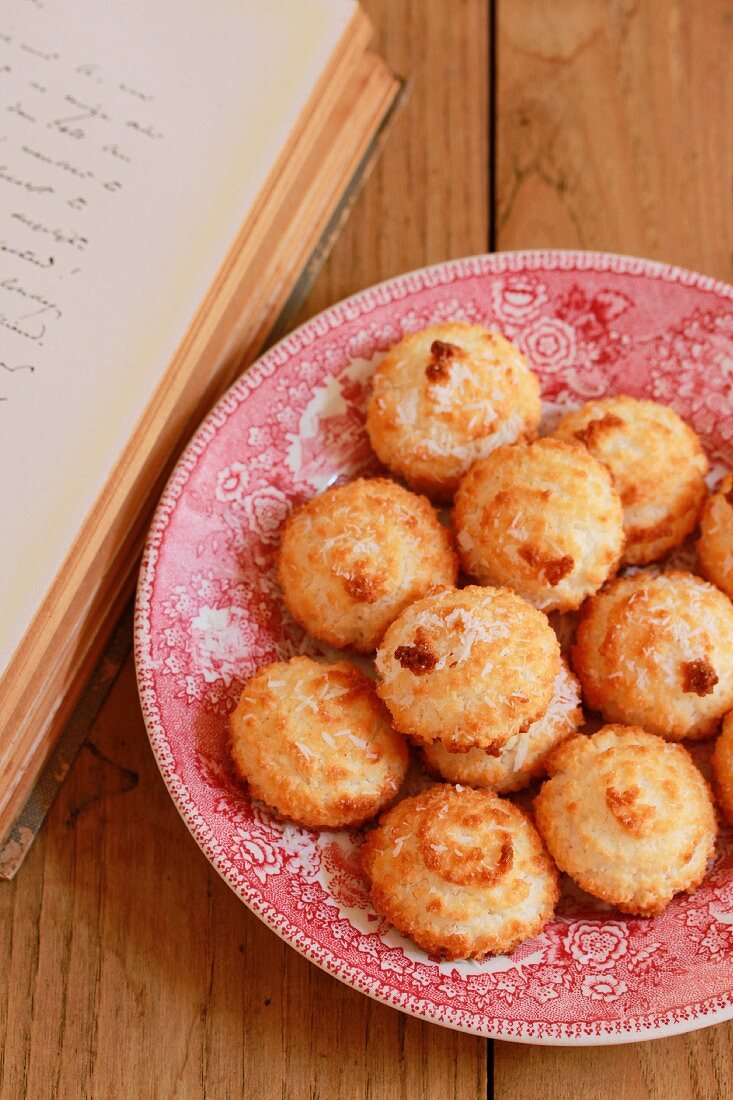 Coconut macaroons on a plate next to a book
