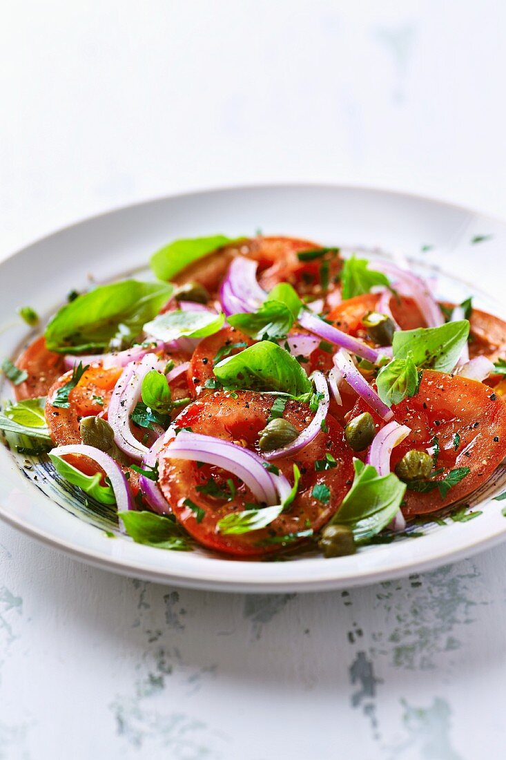 Tomatoes with capers, red onions and basil (close-up)