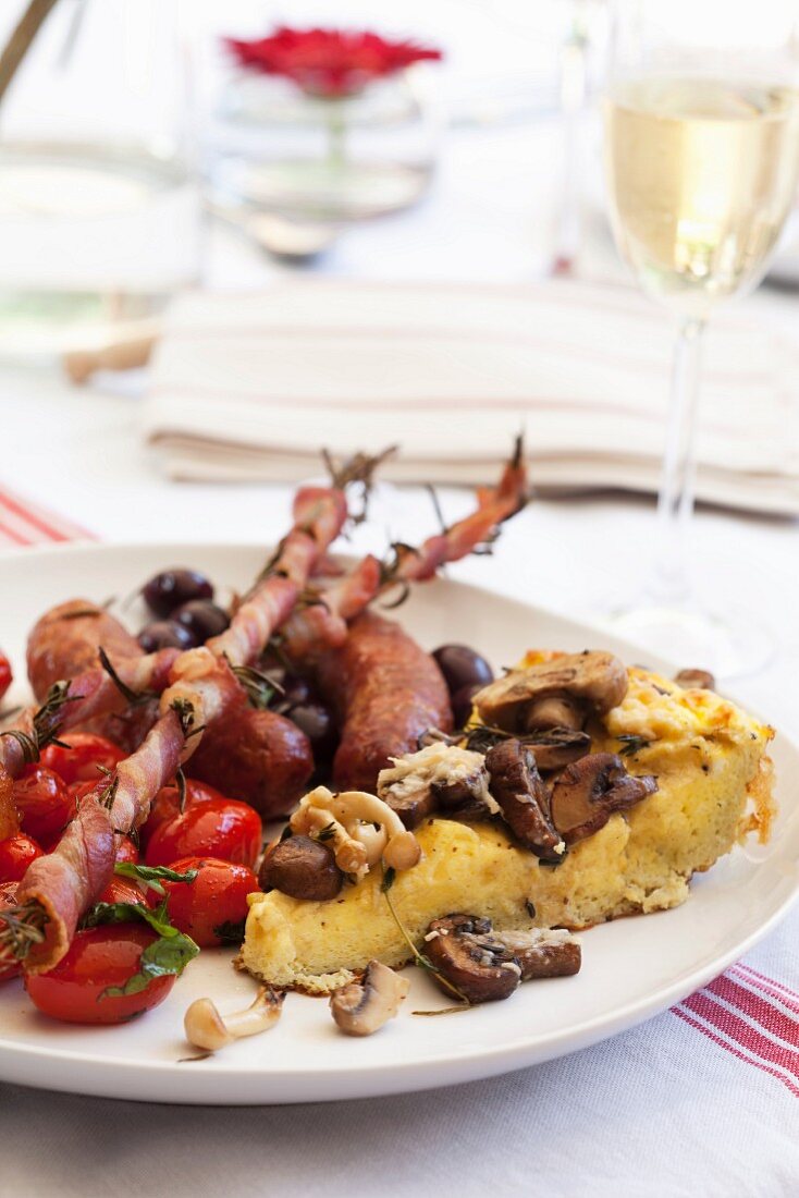 Mushroom frittata with tomatoes, bacon and sausages with grapes