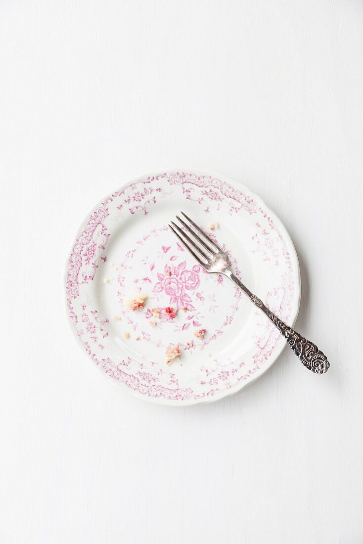 Muffin crumbs and a fork on a vintage plate