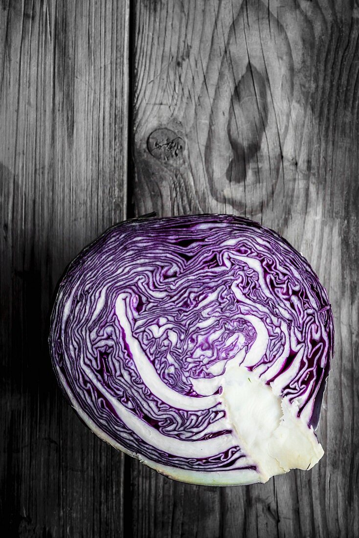 Half a red cabbage on a wooden surface
