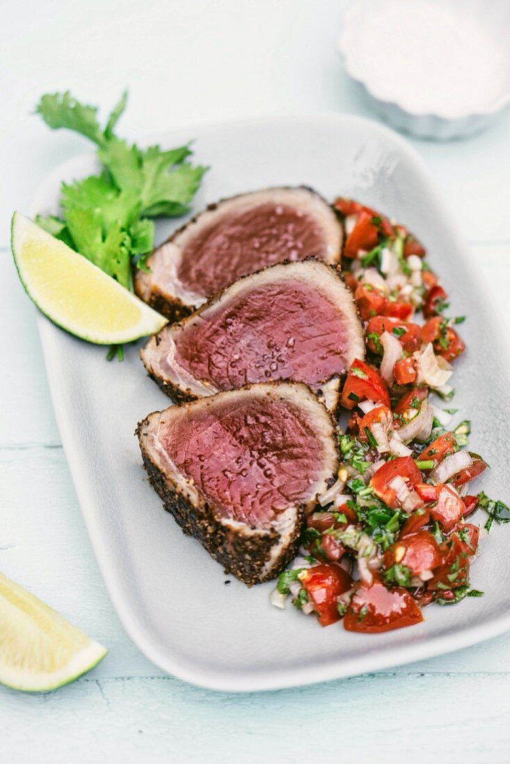 Tuna fish steaks with a sesame seed crust served with fennel seeds, coriander and a tomato and onion salsa