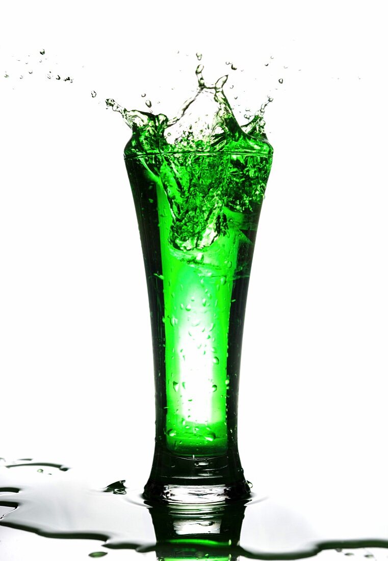 Grünes Getränk spritzt aus dem Glas