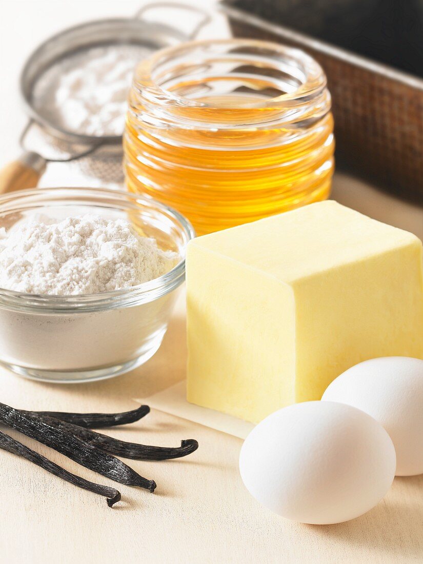 Various baking ingredients (vanilla pods, eggs, butter, flour, honey)