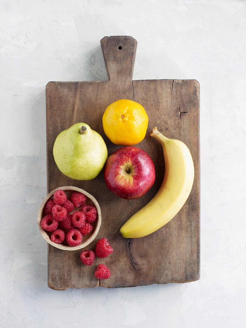 Verschiedene Sorten Obst auf Holzbrett (Aufsicht)