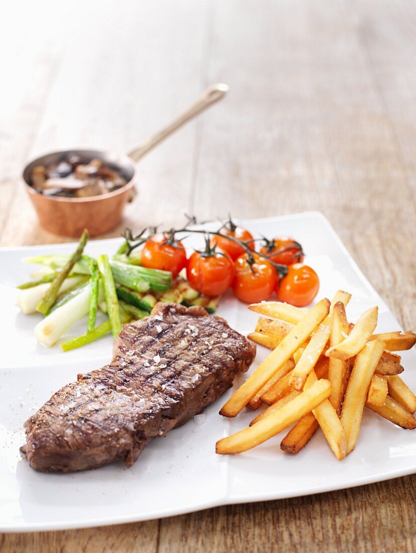 Grilled steak with chips and grilled vegetables