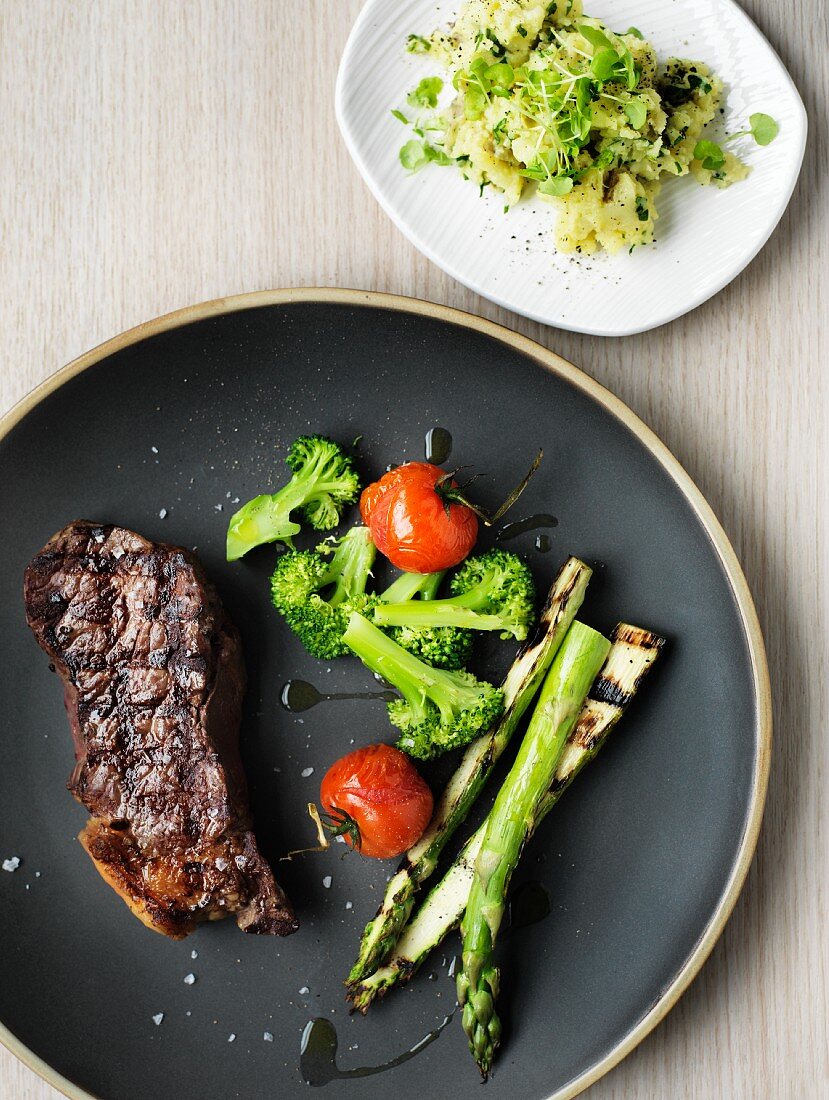 Beef steak with grilled asparagus and potato salad