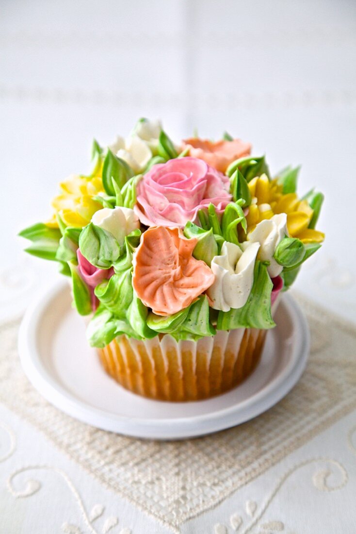 A cupcake decorated with romantic sugar flowers