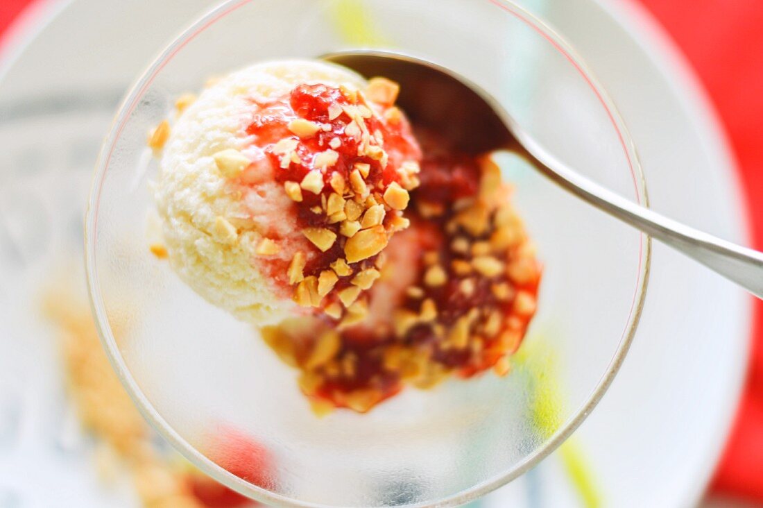 A strawberry ice cream sundae with chopped nuts