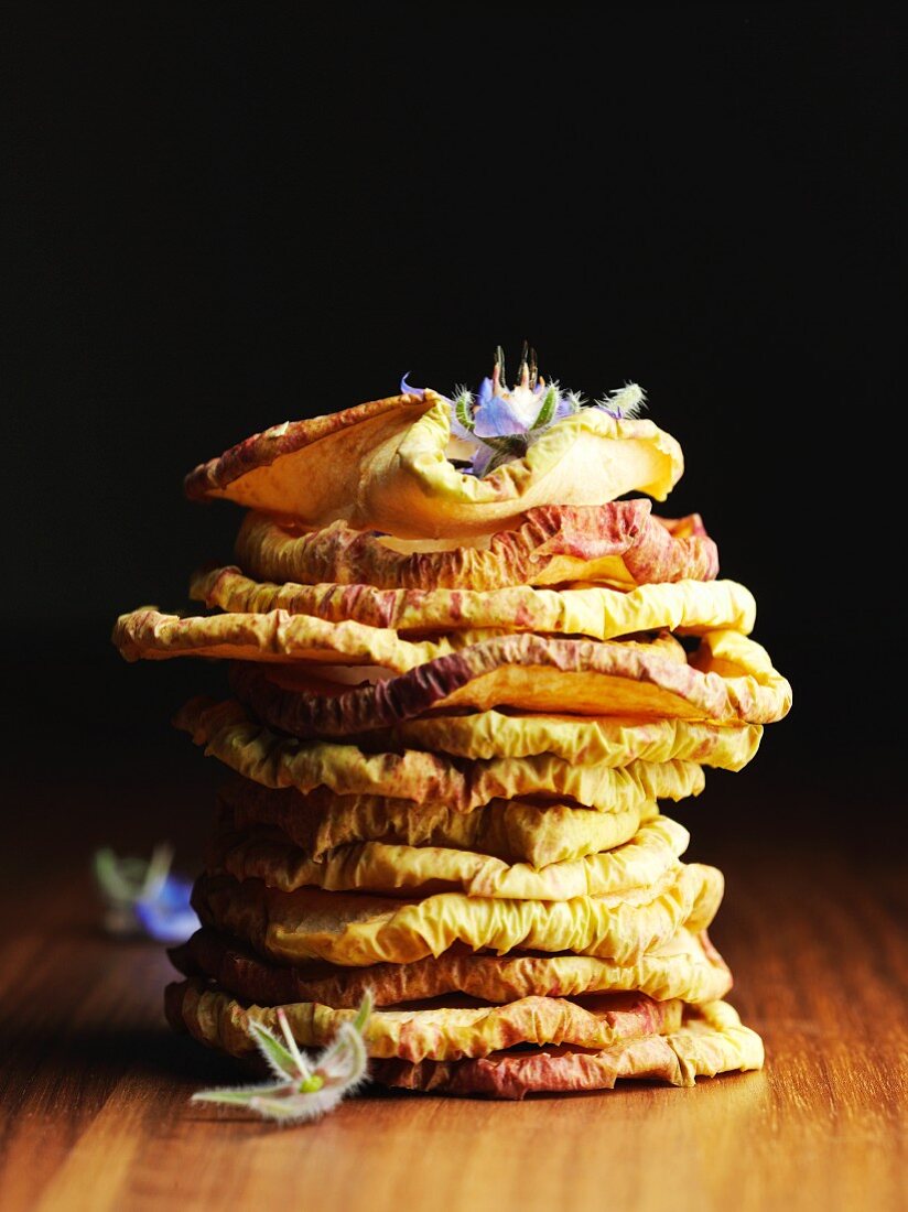 A stack of dried apple rings with borage flowers