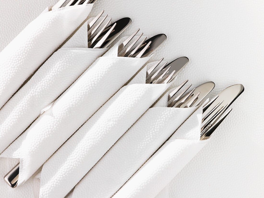 Cutlery wrapped in white napkins