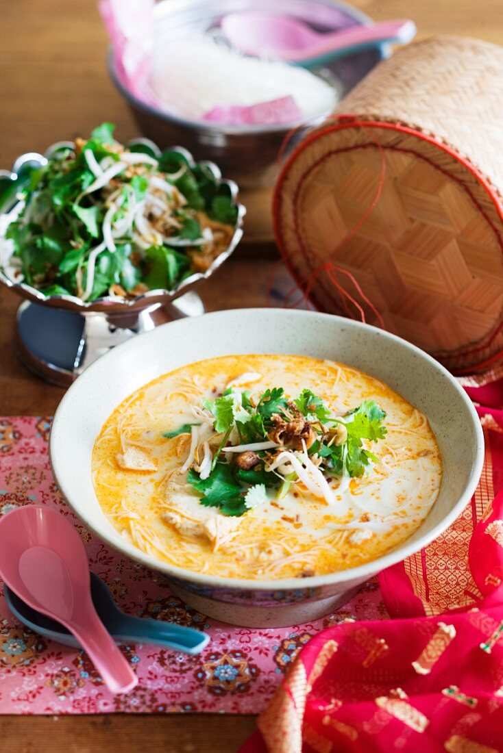 Spicy coconut milk soup with chicken and rice noodles