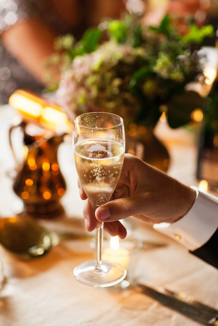 Hand holding a glass of champagne
