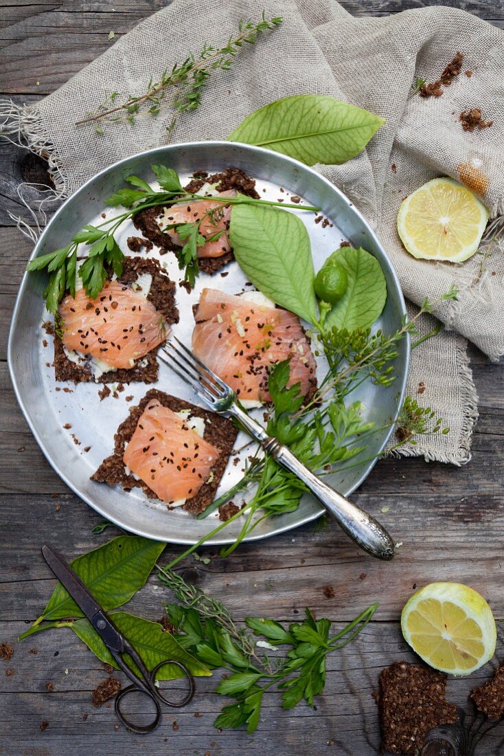 Wholemeal bread topped with butter, smoked salmon and sesame seeds