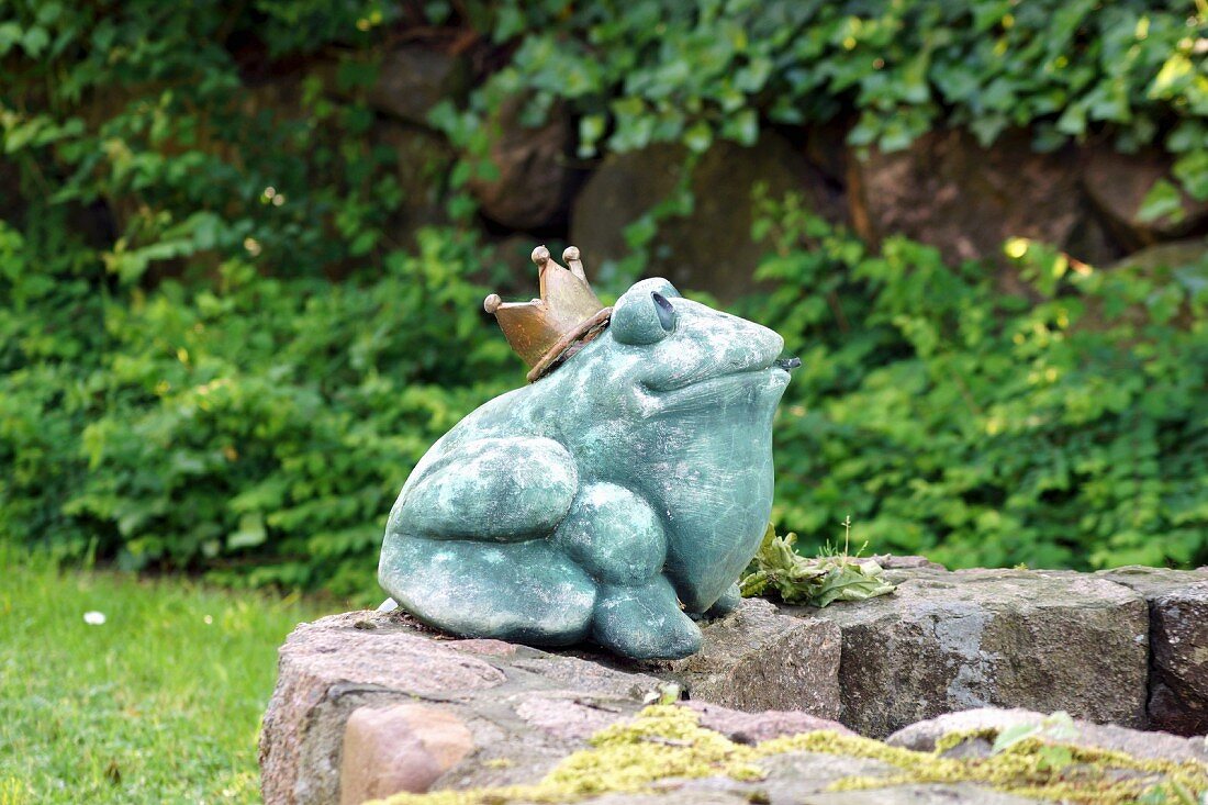 Gartendeko: Froschkönig aus Stein auf Brunnenrand