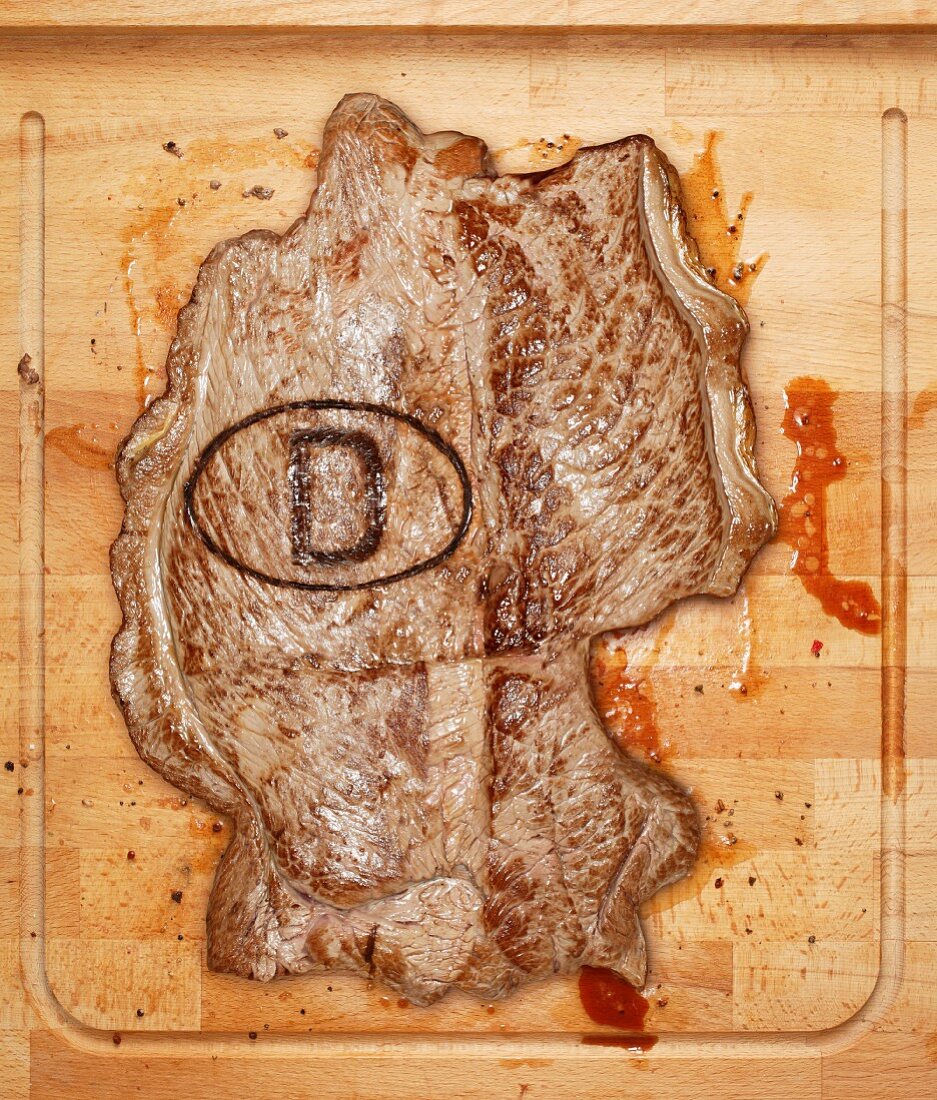 A beef steak with a German stamp on a chopping board