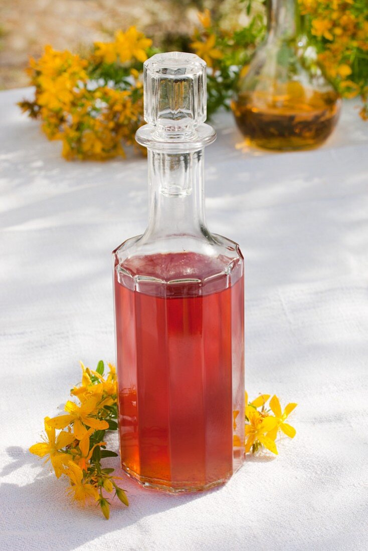Glaskaraffe mit selbstgemachtem Rotöl (Johanniskrautblüten in Olivenöl)