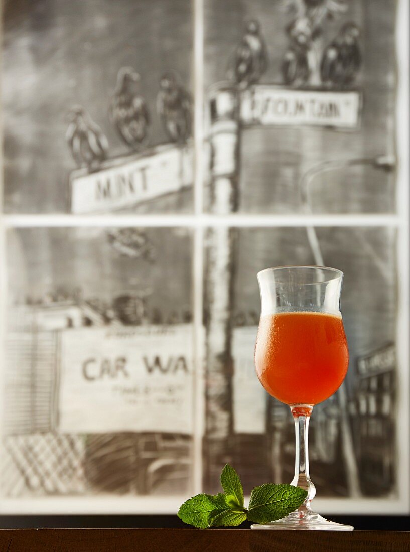 A Mint Junction cocktail made with whiskey, Aperol and orange juice