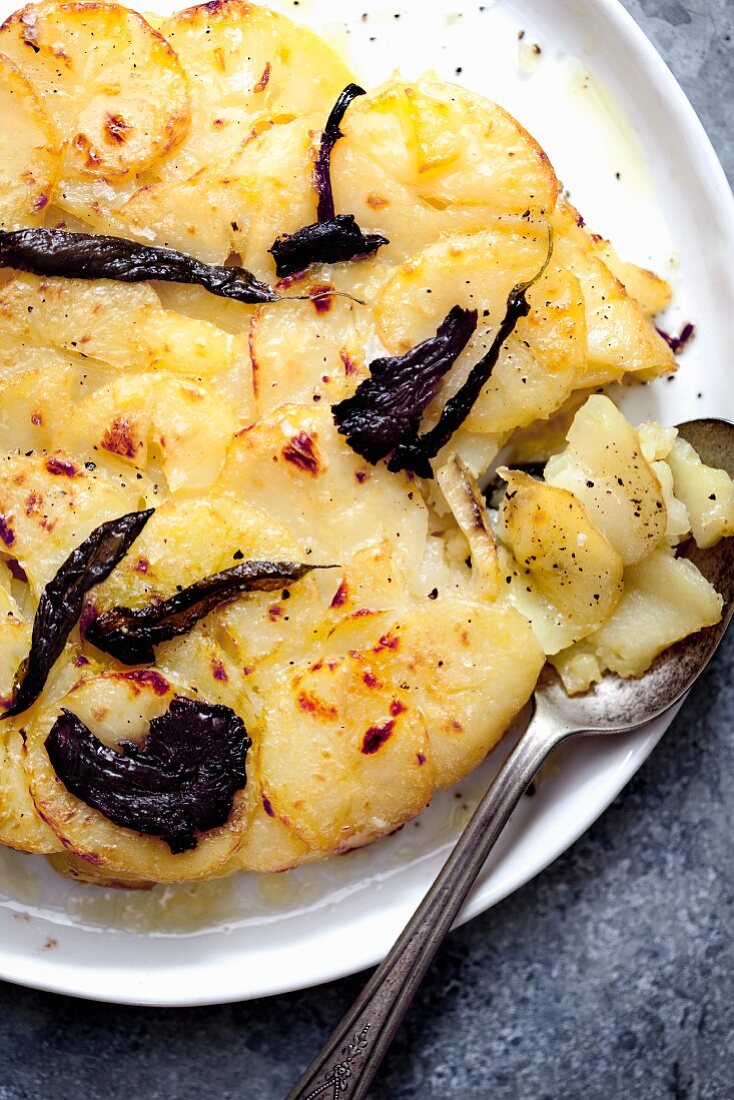 Potato gratin on a plate with a spoon