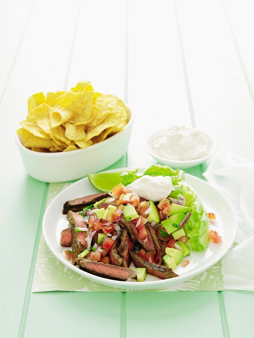 Tangy beef steak with avocado salsa and crisps