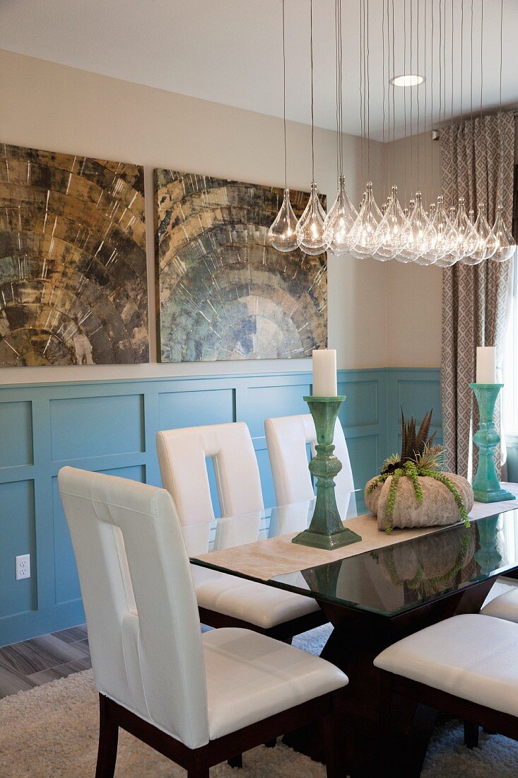 Chairs around dining table below pendant lamps; Menifee; California; USA