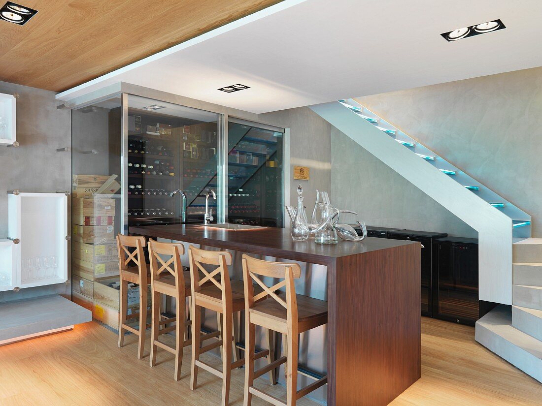 Wine bottles in glass rack and wooden stools at bar counter; Scottsdale; USA