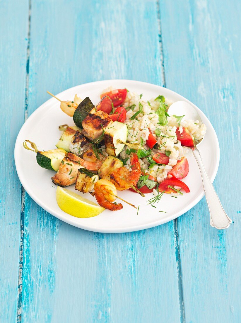 Salmon and courgette skewers with prawns served with rice and tomatoes