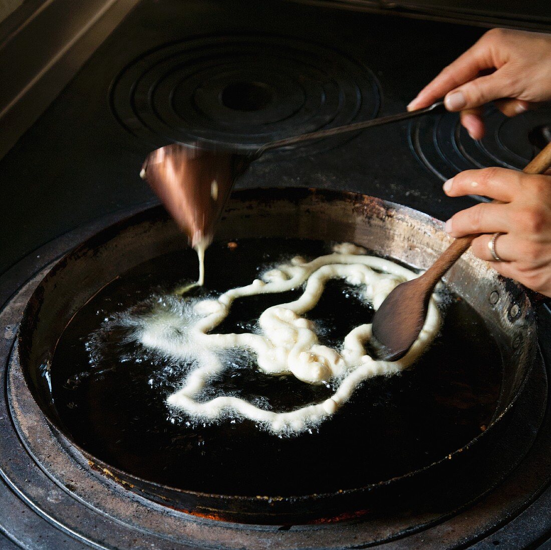 Raw batter being added to hot oil