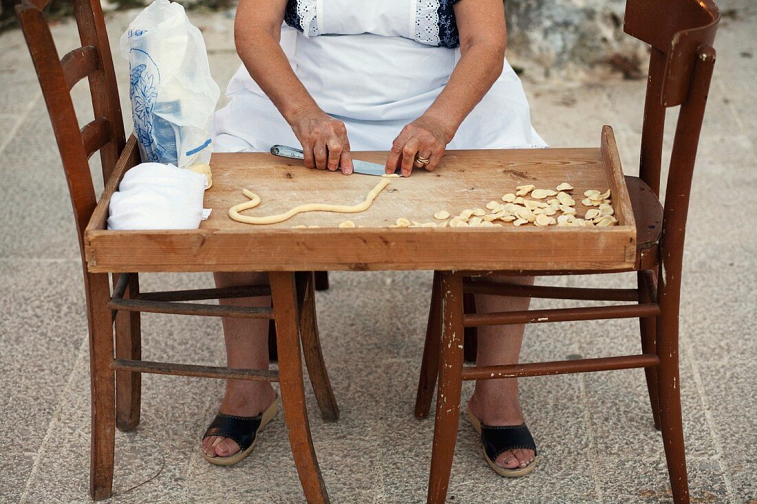 Apulische Frau bei der Herstellung von Orecchiette-Nudeln
