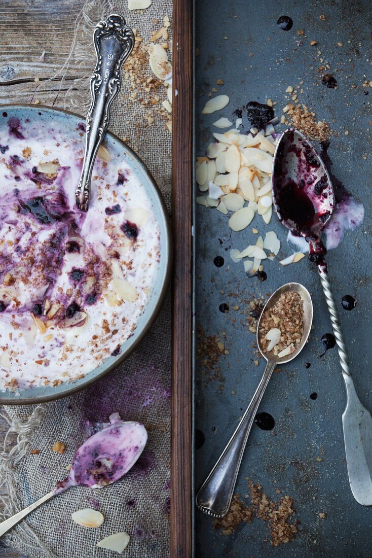 Yogurt dessert with fresh blackberry compote, cereals and flaked almonds