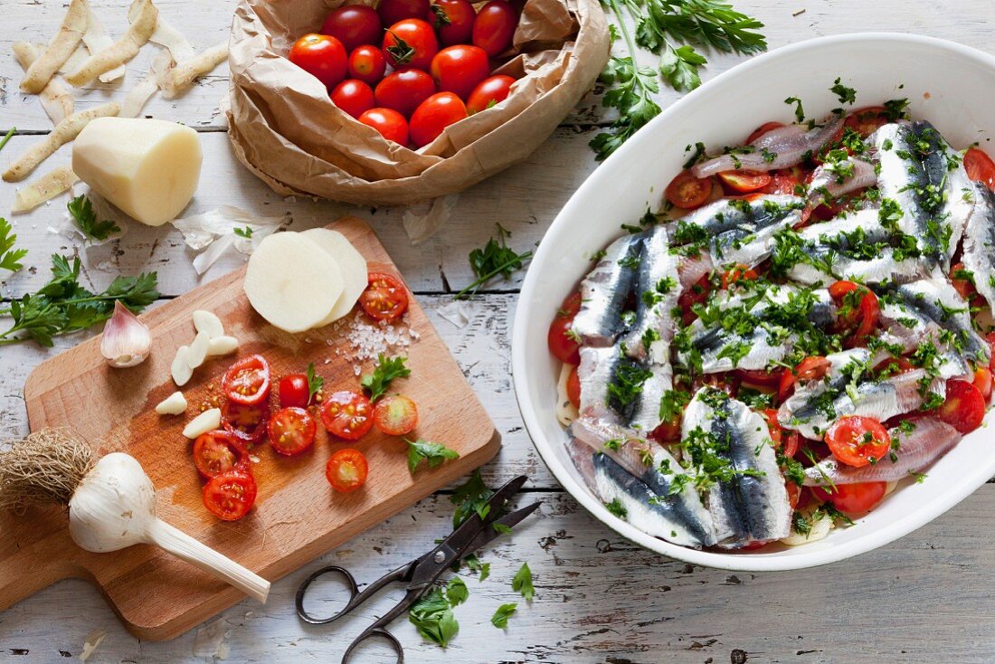 Sardine bake with potatoes, garlic, cherry tomatoes and parsley