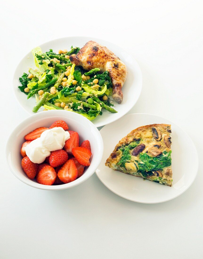 A healthy meal of chicken, vegetables, frittata and strawberries