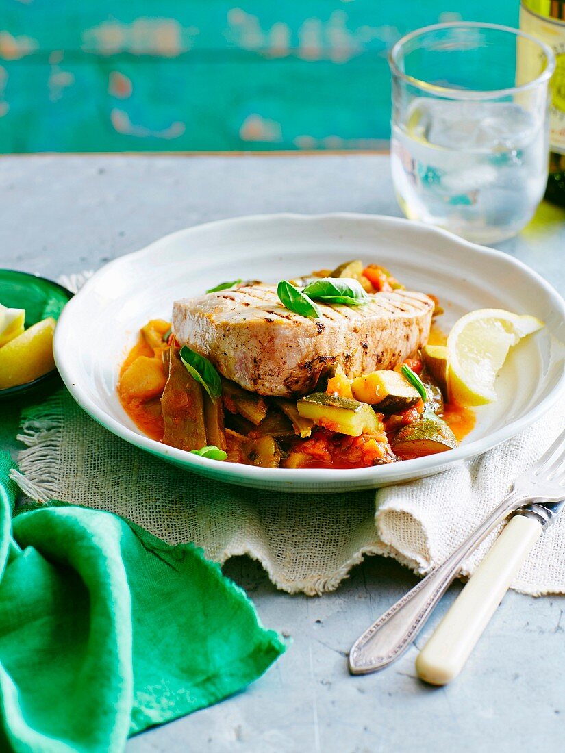 Tuna fish steak on a bean and tomato medley with lemons and basil