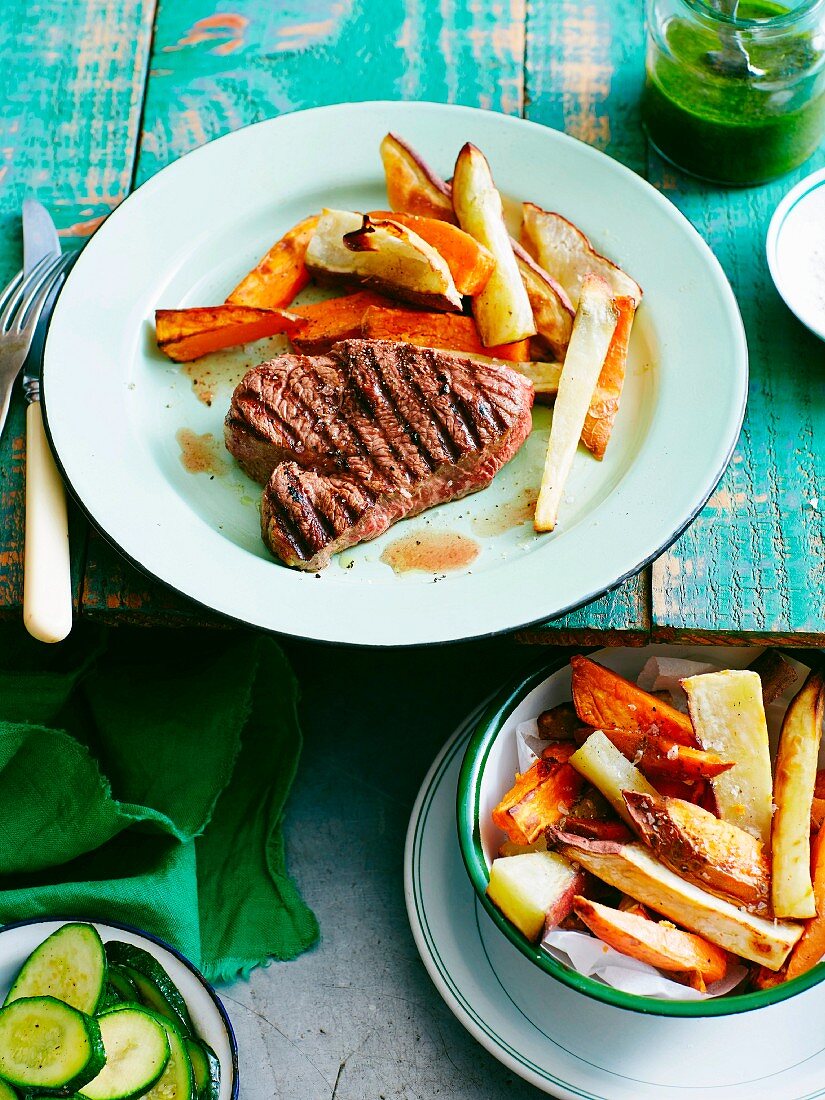 Grilled steak with sweet potatoes and root vegetables and salsa verde