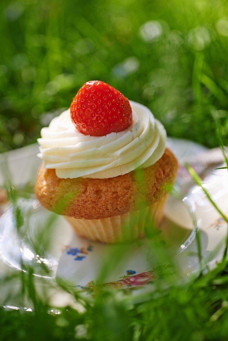 Cupcake mit Buttercreme und Erdbeere