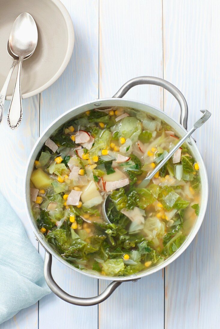 Savoy cabbage soup with potatoes, ham and sweetcorn