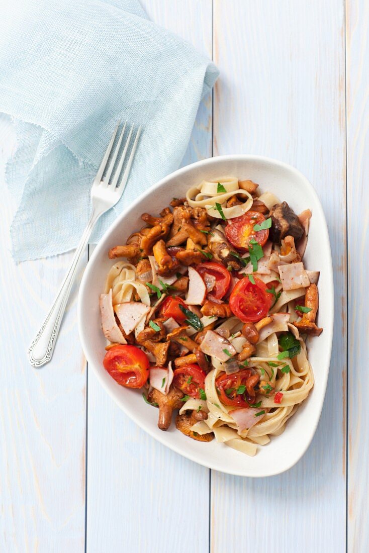 Tagliatelle with chanterelle mushrooms, ham and tomatoes