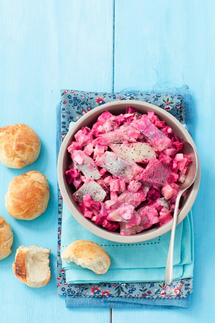 Herring salad with beetroot and egg served with homemade bread rolls