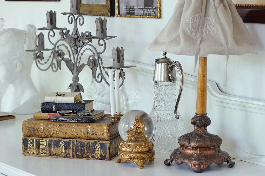 Antiquarian books, gilt snow globe with figurine of Mary and vintage-style table lamp