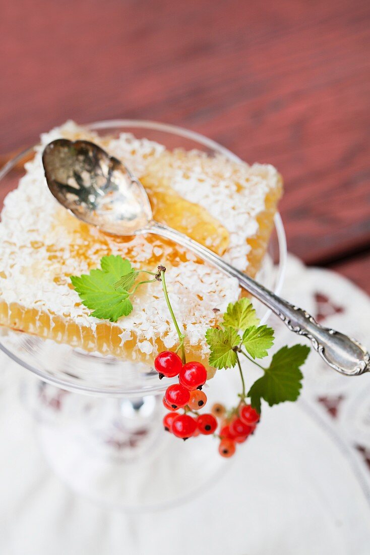 Honeycomb with redcurrants (close-up)