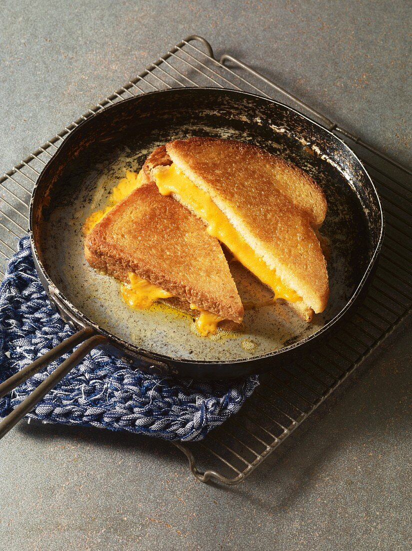 A grilled cheese sandwich being fried in a pan