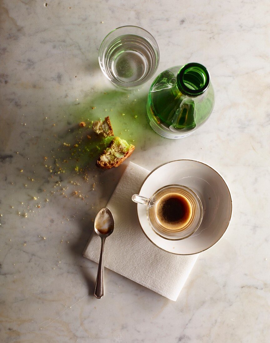 Espresso in a cup with a bottle and biscotti