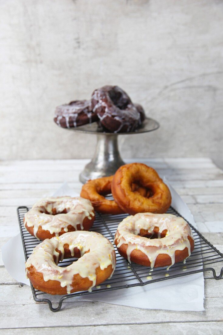 Glazed doughnuts on a wire rack and a cake stand
