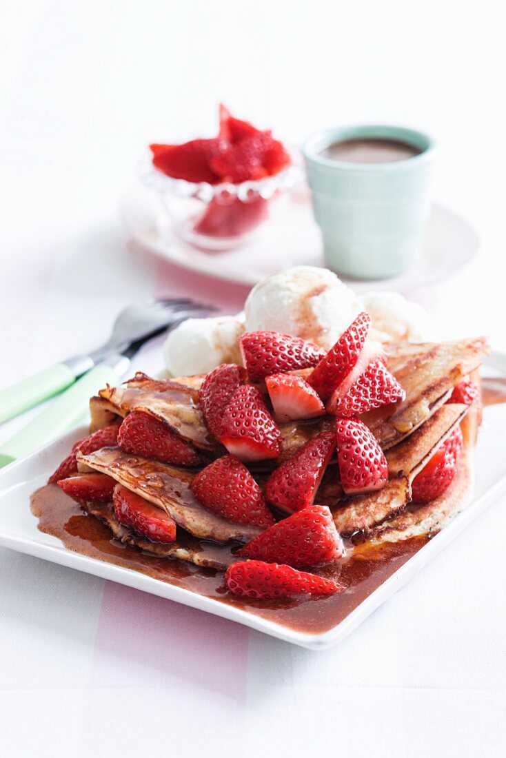 Pancakes mit Ahornsirup, Eis und Erdbeeren