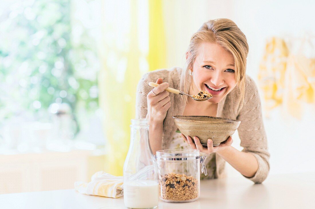 A blonde woman eating muesli